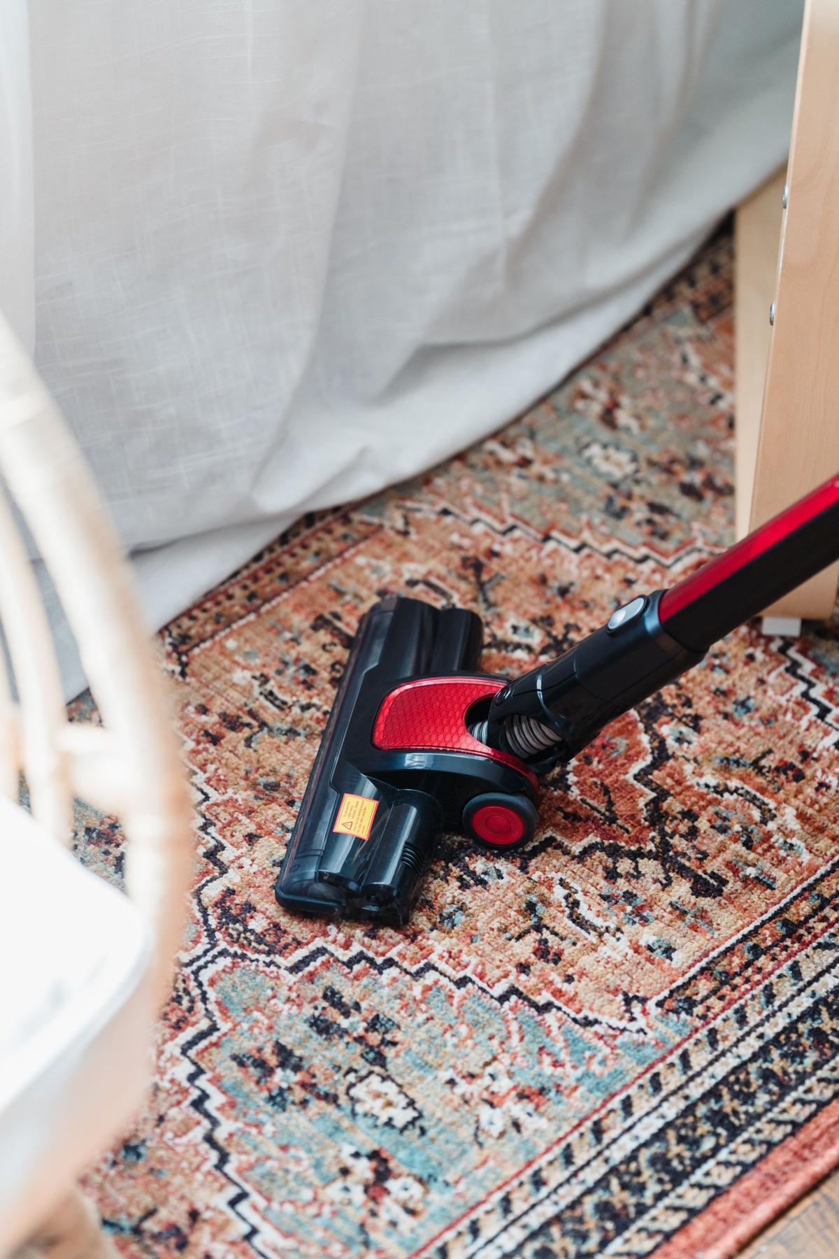 Vacuum cleaner passing over a patterned area rug