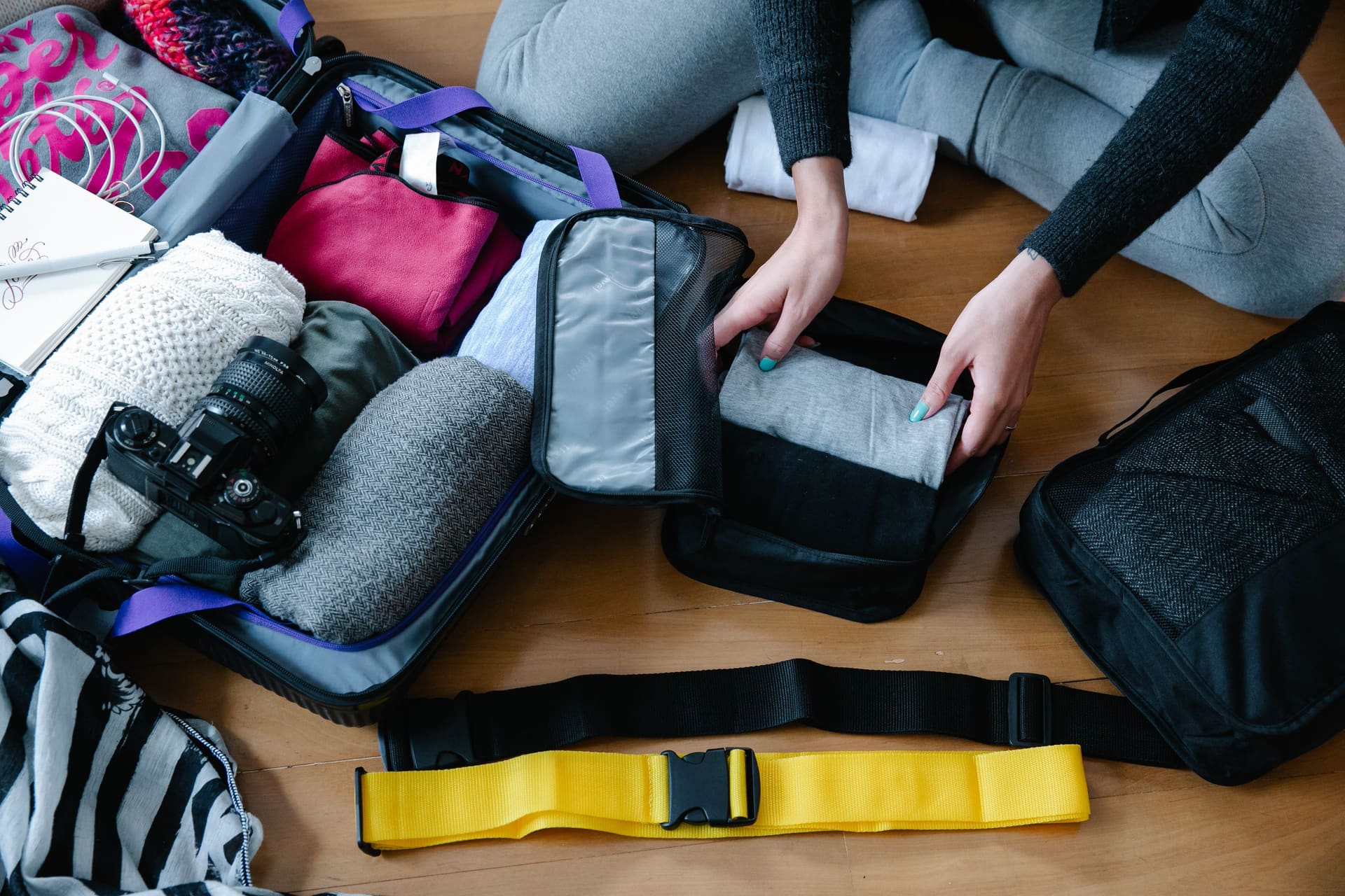 Traveler arranging folded clothes inside zippered packing cubes