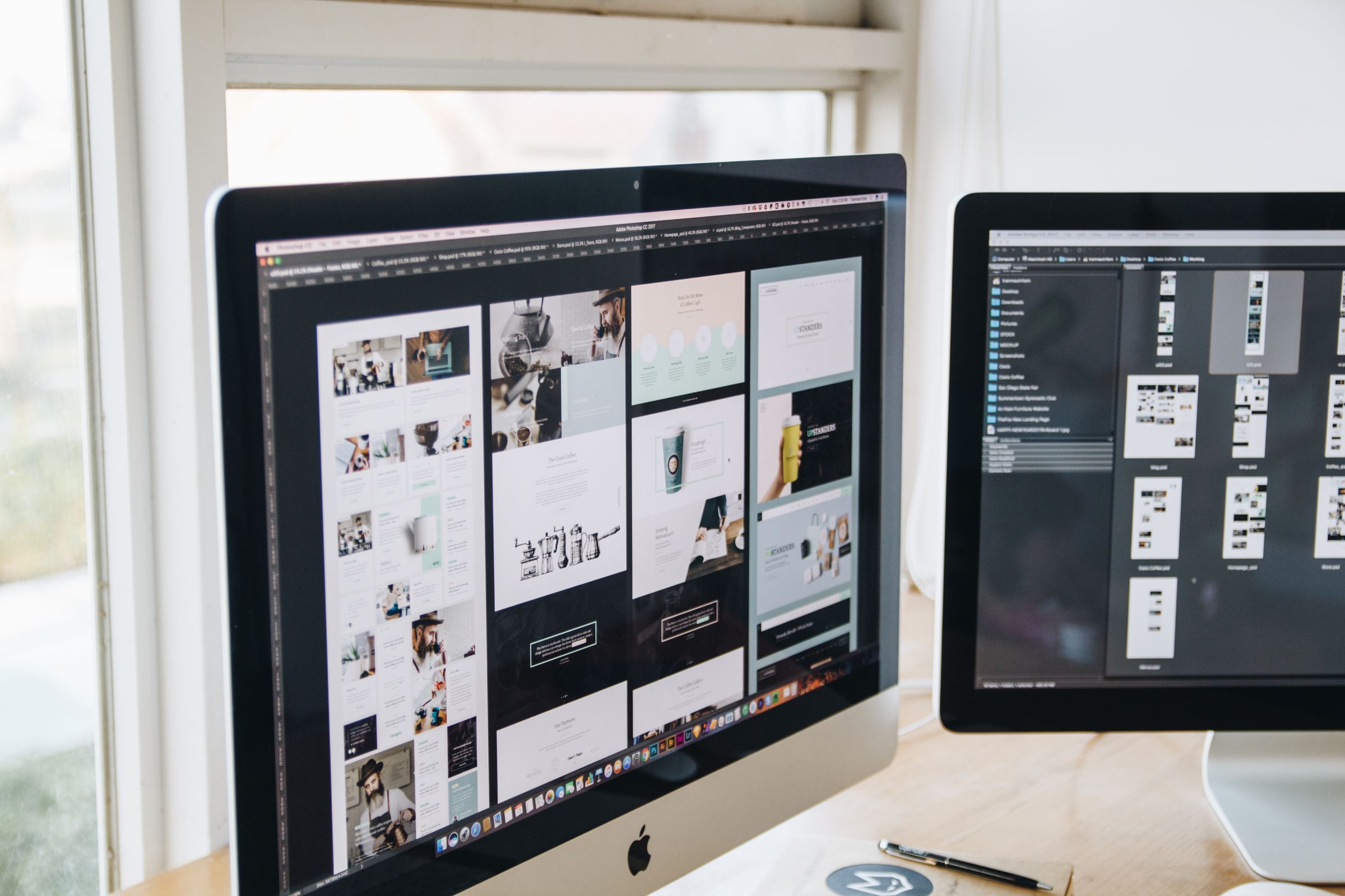 Dual computer monitors displaying detailed design work at a desk