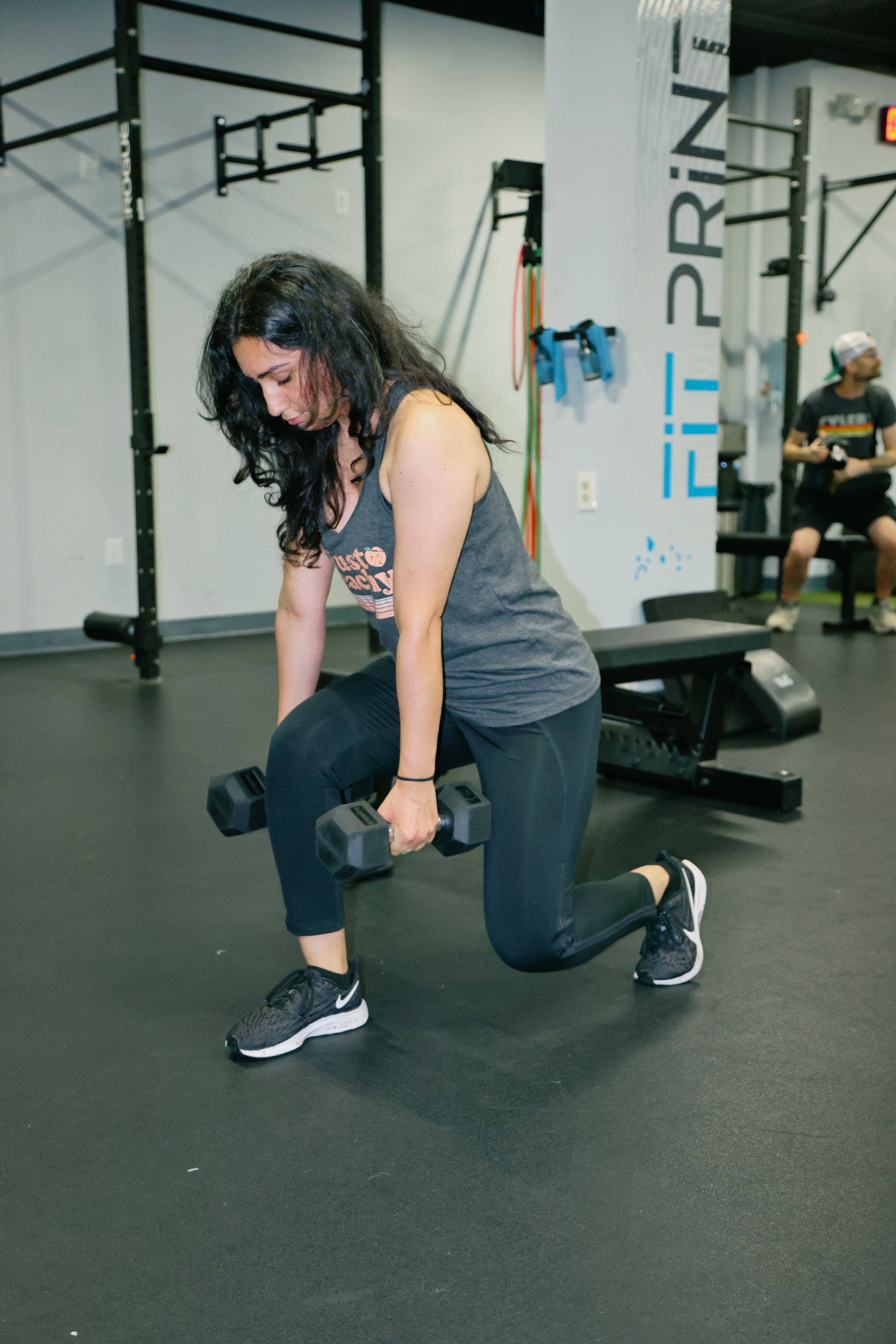 Woman performing a dumbbell lunge during a strength workout