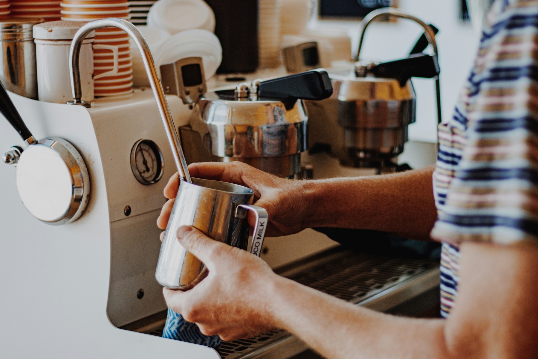 Barista steaming milk with an espresso machine steam wand