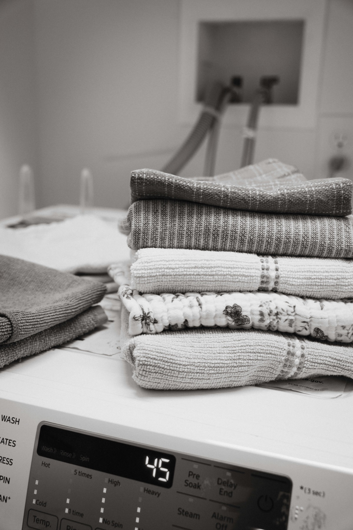 Freshly folded blankets and towels on a washing machine