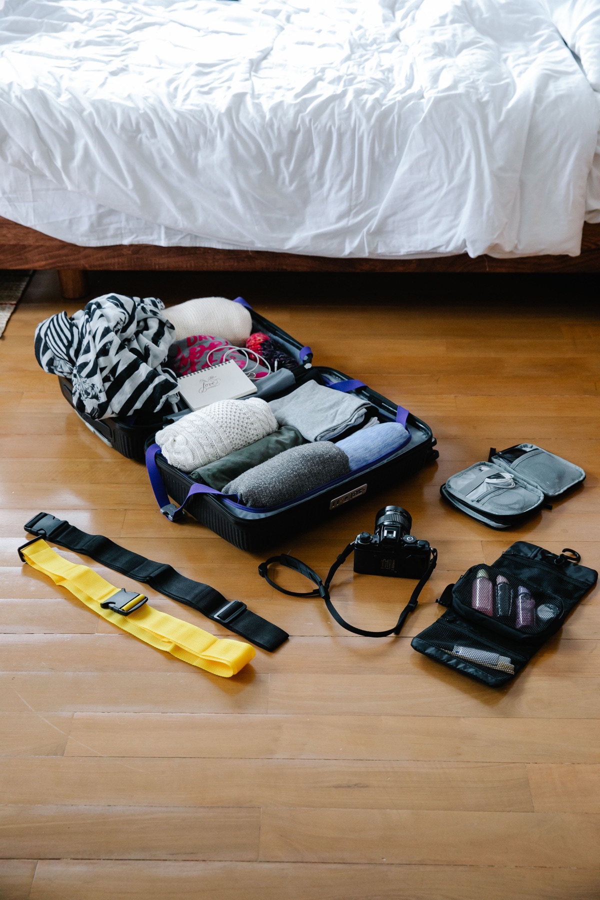 Open suitcase with clothes and travel essentials arranged for packing