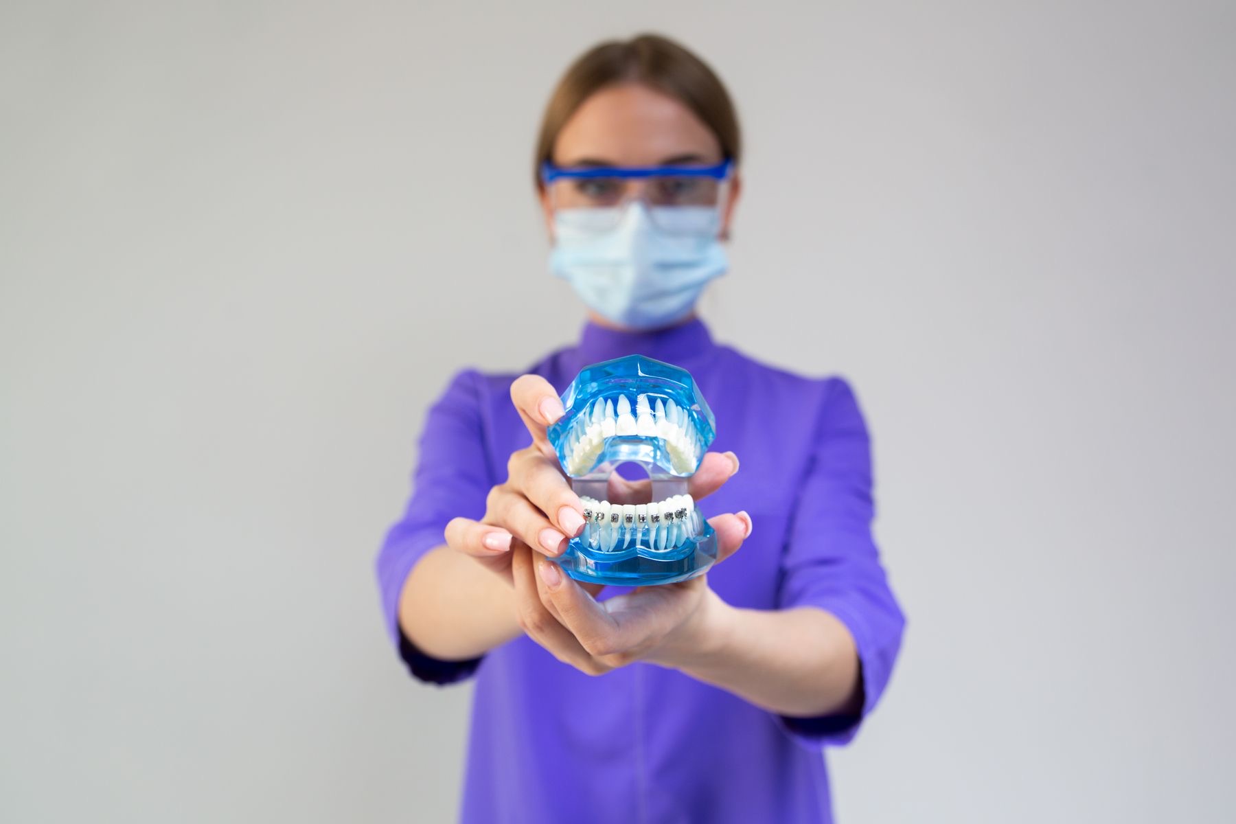 Dentist holding a dental model fitted with braces