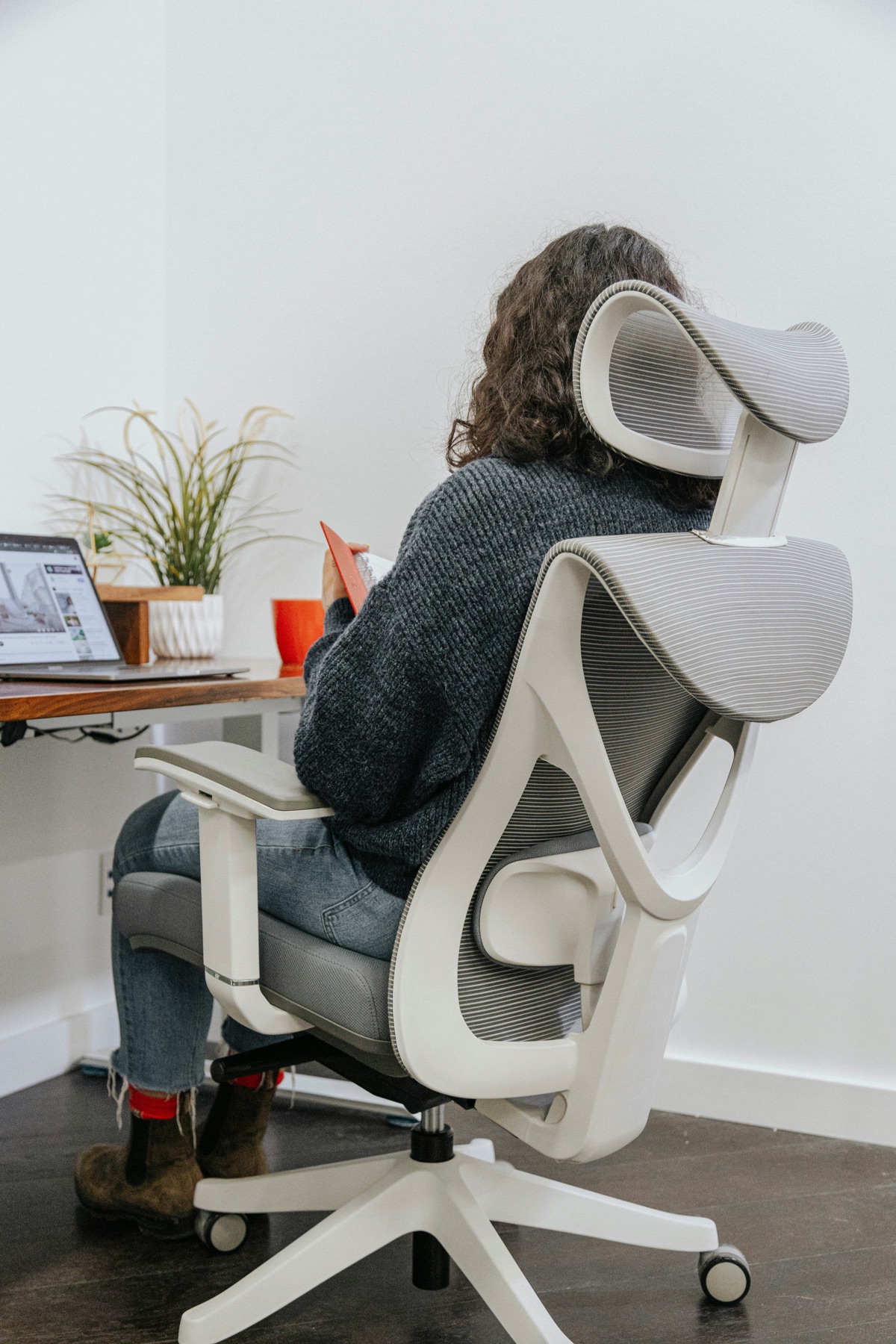 Person sitting in an ergonomic office chair at a desk
