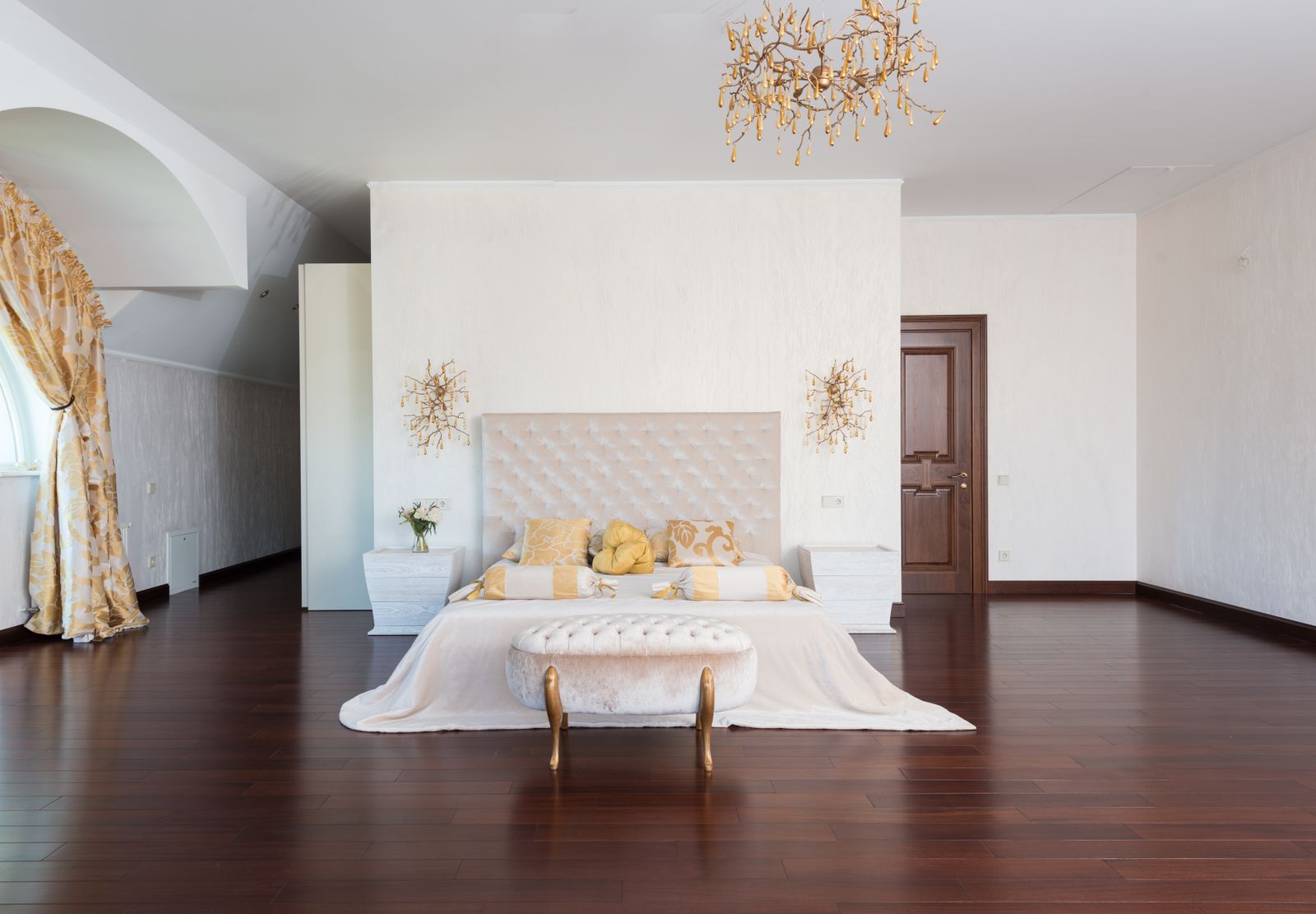 Spacious bedroom furnished with a queen-size bed and upholstered headboard