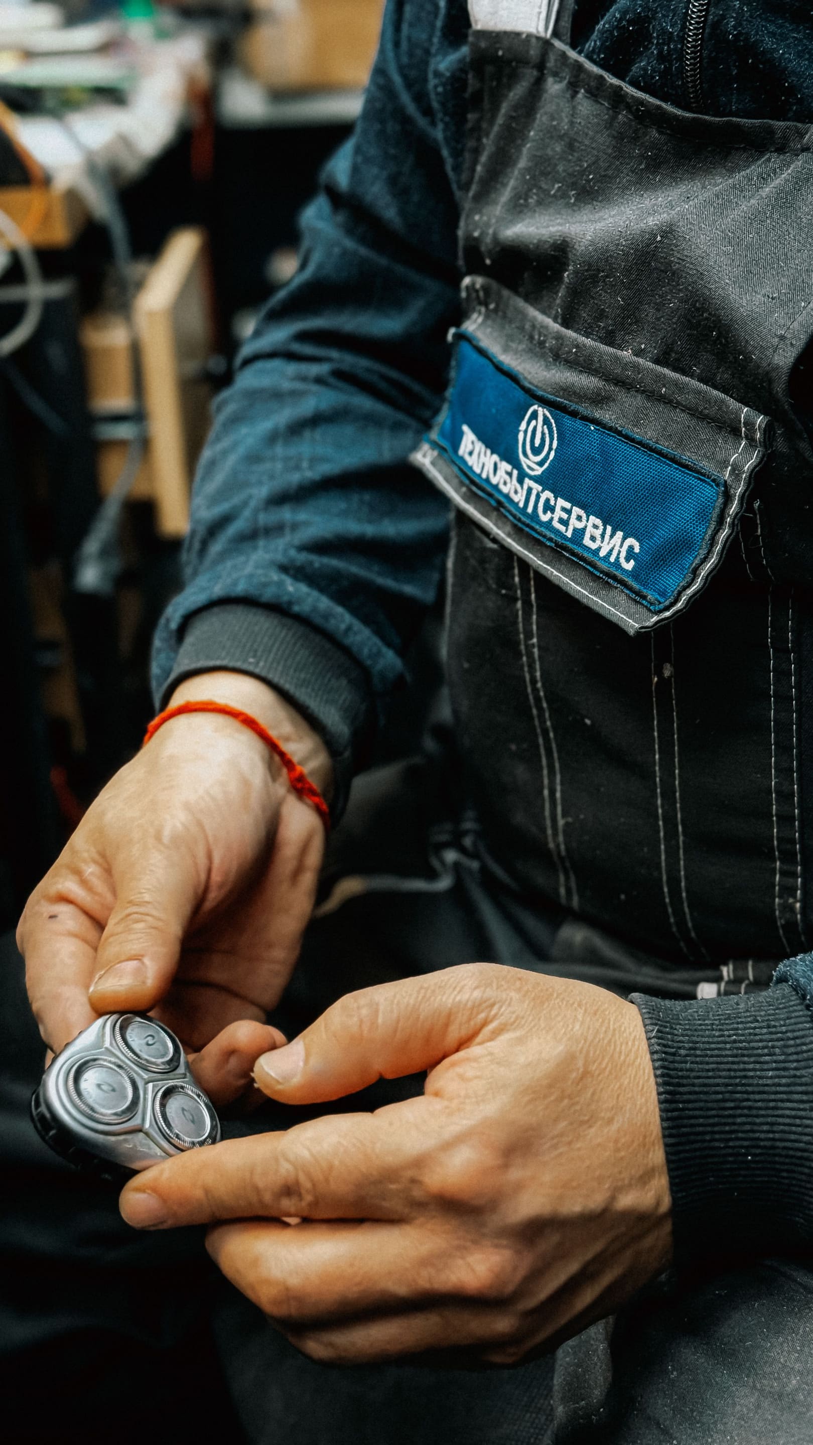 Technician inspecting the rotary head of an electric shaver