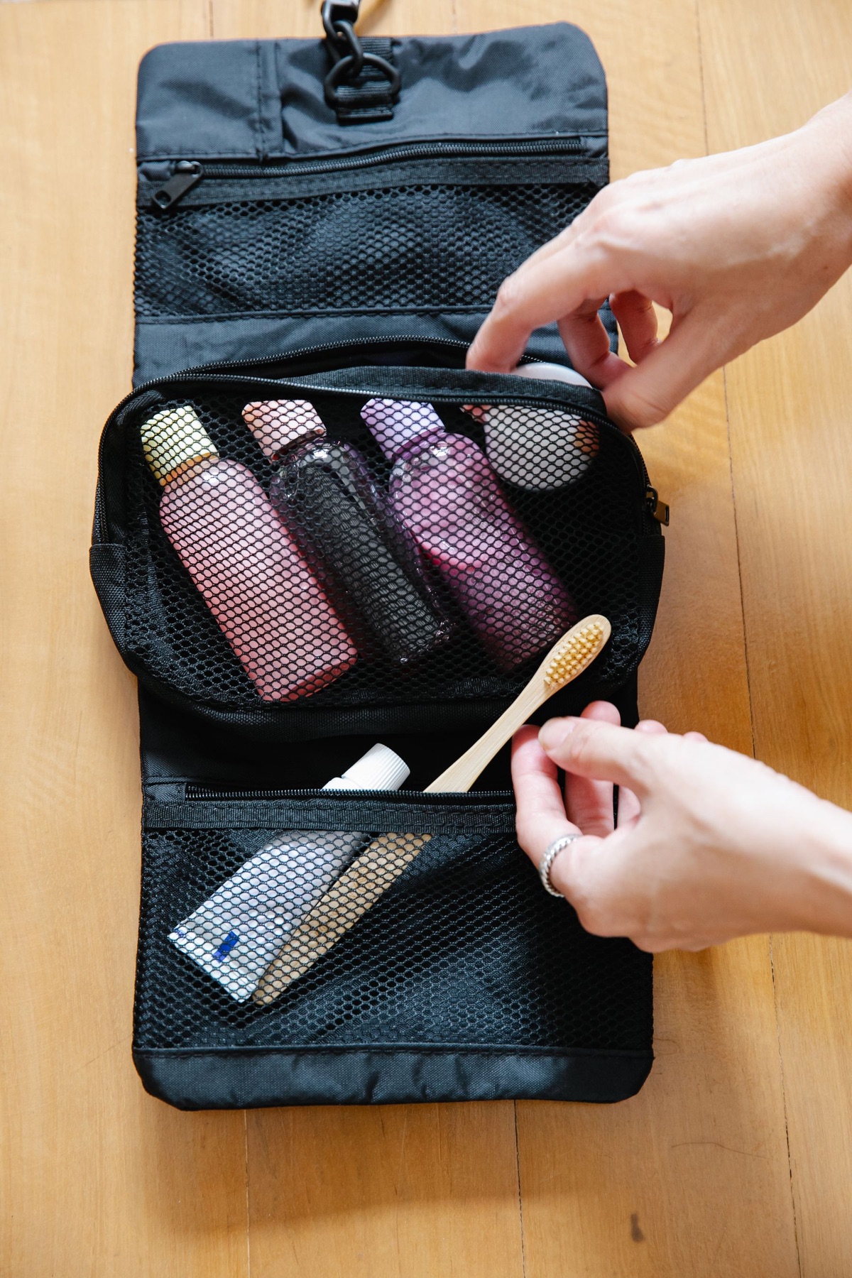 Open black toiletry bag filled with travel-size bottles